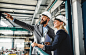 A portrait of an industrial man and woman engineer with tablet in a factory, working.