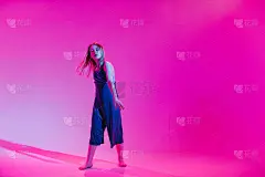 年轻时髦的女孩在彩色霓虹灯背景下在工作室跳舞。音乐dj海报设计。