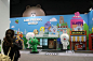 This may contain: a group of people standing in front of a building with cartoon characters on the walls