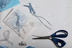 制作贺卡。白色桌面上的工艺品配件。干花和工艺品缎带。创造力的工具。
