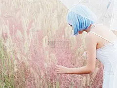 这是一幅美丽的年轻中国女子的肖像，她穿着白色的吊带裙，站在粉红色的满头鲜花和感人的花朵中间。情感、人