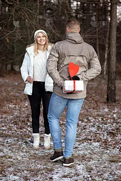 快乐的金发女郎因期待情人节的礼物而僵住了。红心是所有恋人的象征。约会的概念。爱的宣言。森林里的浪漫约