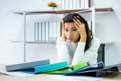 年轻的亚洲妇女压力与她的业务网上购物在办公室。枯燥的商务办公生活理念。