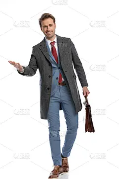 快乐的商人微笑着，提着行李箱向身边走来