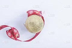 一个金色的闪闪发光的球与红色的圣诞丝带在白色的背景