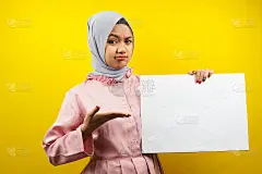 漂亮的年轻穆斯林妇女思考，手握空白的空横幅，海报，白板，空白招牌板，白色广告牌，呈现在复制空间，促销