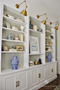 Cabinets below, shelves above, accent color behind, sconces to light: 