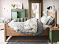 配有 HURDAL 实木床、SISSELA 花朵图案床上用品和 HURDAL 绿色储物件的绿色卧室