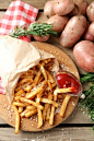 Tasty french fries on cutting board, on wooden table background :: Stock Photography Agency :: Pixel-Shot Studio