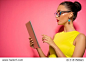 Youth and technology. Colorful studio portrait of young attractive brunette woman using tablet computer against pink wall.