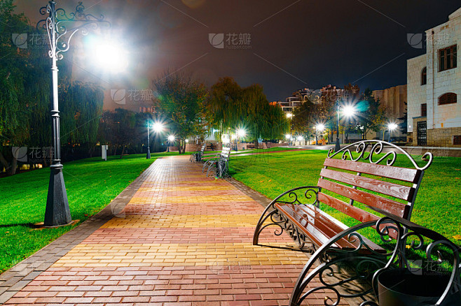秋天的城市公园晚上，黄叶树，路灯和长椅