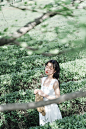 woman in white sleeveless dress holding brown woven basket