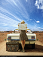 Caucasian woman with convertible reading map on remote road - stock photo