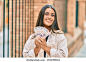 Young hispanic girl smiling happy holding mexican 500 pesos banknotes at the city. 库存照片