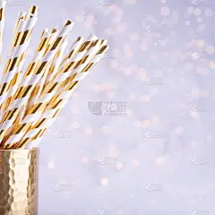 金杯子里有金色和白色的纸吸管。圣诞节的概念。节日派对背景