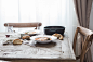 Two deep dishes with a hearty meal, pieces of bread and wine glasses on a wooden table