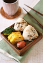 Small meal rice ball of takikomi-gohan (a rice dish seasoned with soy sauce and boiled with various ingredients), tamagoyaki (Japanese omelette), umeboshi (pickled ume), broccoli ingredients of takikomi-gohan : rice, carrot, burdock, lotus root, hijiki, c