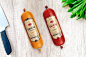 two bottles of sauce next to a knife on a table