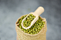 Green mung beans in the sack with wooden scoop - mung bean seed cereal whole grains Premium Photo