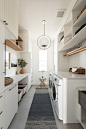 Large transitional galley gray floor dedicated laundry room photo in Dallas with a farmhouse sink, white cabinets, white walls, beige countertops, flat-panel cabinets and a side-by-side washer/dryer