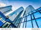 Bottom view of modern skyscrapers in business district against blue sky