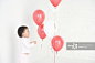 Baby girl (15-18 months) standing in studio, looking at balloons - 创意图片 - 视觉中国