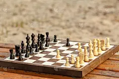 木凳上放着棋子的棋盘。户外棋类游戏