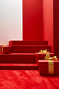 Gift boxes are sitting on red carpet with gold ribbon, in the style of pop-inspired installations, trompe l’oeil, minimalist abstracts, candid moments captured, happenings, red, xmaspunk