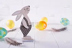 复活节构图用五颜六色的复活节彩蛋，装饰木制的小兔子。刻字的模板