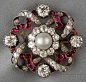 Antique Pearl, Ruby, and Diamond Brooch, Austria-Hungary, centering a pearl measuring approx. 8.50 mm, and bezel-set with four old European-cut diamonds each weighing approx. 0.90 cts., and old mine and old European-cut diamonds, and cushion-cut rubies, a