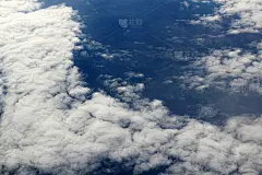 飞机在云层上面飞得很高。窗外的景色。阳光明媚的一天。自然背景。旅行的概念。