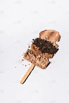 米色粉底笔刷及白底木棍眼影粉的顶视图