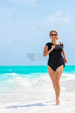 美丽的吹着头发的女人正在梦想的海滩上奔跑
