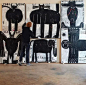 This may contain: a man standing in front of three black and white paintings on the wall with animals painted on them