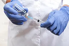 抗击covid-19，医生手持注射器和小瓶疫苗，儿童和青少年接种概念