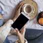 Woman holding smartphone and cup of coffee Free Photo