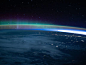 An aurora dimly intersects with Earth's airglow