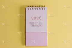 2022年的日历。桌面日历计划，分配，组织和管理每个日期。黄色背景上的粉色日历。