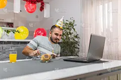 年轻的白人男子点燃生日蜡烛，与朋友们在集体视频通话，因为封锁