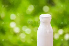 瓶子塑料白色的木材和树木模糊的散景背景在花园里。使用壁纸包装与产品形象。