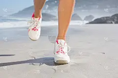 一个健康的女人在海滩上散步