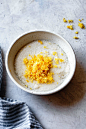 Vibrant lemon zest sits atop a bowl of sugar