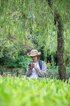 手拿单反相机摄影徒步旅行男生人物摄影图