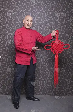 穿着中国传统服装的老人，手里拿着打结