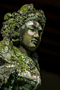 Stock photograph of a moss and lichen covered basalt statue of a Ramayana goddess in Bali