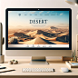 Create an image of a computer monitor on a desk displaying a website with a desert theme. The website should feature a captivating header image of a vast desert landscape with 'DESERT' written across it in bold letters. The navigation bar should include i
