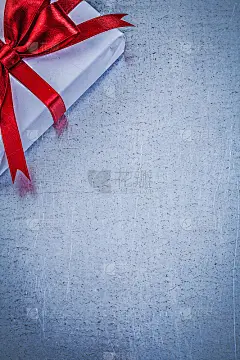 包装礼品与红色蝴蝶结的金属背景假日概念