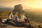 在度假期间，一群年轻的游客在著名的岩石高原狮子峰的背景下放松和观看多彩的日落。斯里兰卡