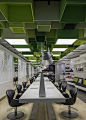 Swedish studio Sweco Architects has covered the ceiling of this hair salon in Umeå with 85 green MDF boxes.