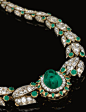 EMERALD AND DIAMOND NECKLACE, LATE 19TH CENTURY Set at the centre with a cabochon emerald bordered with circular-cut diamonds and kite-shaped emeralds, continuing to a series of graduated stylised lotus links set with rose, oval, single- and circular-cut,